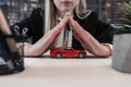 Protection of car. Business woman hold small toy red vehicle in her hand for insurance at office Royalty Free Stock Photo