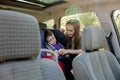 Protection in the car. Hands of caucasian woman is fastening security belt to child, who is sitting in safety car seat or chair. Royalty Free Stock Photo