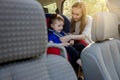 Protection in the car. Hands of caucasian woman is fastening security belt to child, who is sitting in safety car seat Royalty Free Stock Photo