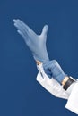 Protection. Cropped shot of male doctor hands putting on blue sterile gloves, isolated against navy blue background Royalty Free Stock Photo
