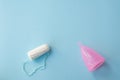 Protection for female hygeine. menstrual cup and tampon on blue background, copy space. Best way for woman menstrual protection