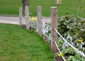 Protection flower bed from the entrance of dogs people bikes other cars separates flower bed  lawn path rope fence wooden posts Royalty Free Stock Photo
