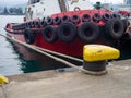 Protection of the sides of the ship in the form of old tires. Scale for submerging a ship in water. Tugboat in the port. The ship Royalty Free Stock Photo