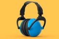 Protective blue earphones muffs isolated on a orange background