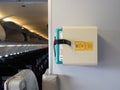 Protective breathing equipment PBE or AVOX in aviation word secured in stowage on aircraft wall at aft galley near cabin crew