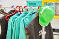 Protective clothes and green safety helmet on a coat rack at factory. Royalty Free Stock Photo