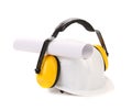 Protective ear muffs and hard hat paper roll. Royalty Free Stock Photo