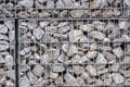 Protective gabions with grey broken stones behind grid as solid fence and solid wall and decorative element in gardens with rough