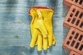 Protective gloves red bricks on wooden board construction concep