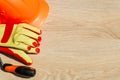 Protective hard hat, headphones, gloves, glasses and masks on wooden background, copy space Royalty Free Stock Photo