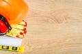 Protective hard hat, headphones, gloves, glasses and masks on wooden background, copy space, top view Royalty Free Stock Photo