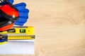 Protective hard hat, headphones, gloves, glasses and roulette on wooden background, copy space Royalty Free Stock Photo