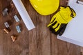 Protective hard work gloves on yellow hard-hat, copper pipes