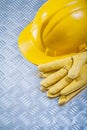 Protective leather gloves hard hat on channeled metal sheet cons Royalty Free Stock Photo