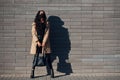 In protective mask. Beautiful brunette with curly hair and in black clothes outdoors near wall Royalty Free Stock Photo