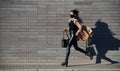 In protective mask. Beautiful brunette with curly hair and in black clothes running outdoors near wall Royalty Free Stock Photo