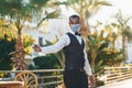 In protective mask. Black waiter in formal clothes is at his work outdoors at sunny daytime Royalty Free Stock Photo