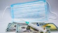 Protective mask, medical items and dollar bills on a white background.