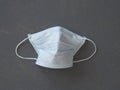 Protective medical face mask on a gray background of painted wood-chipboard. Coronavirus protection mask, empty space.The view Royalty Free Stock Photo