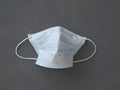 Protective medical face mask on a gray background of painted wood-chipboard. Coronavirus protection mask, empty space. The view Royalty Free Stock Photo