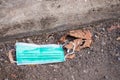 Protective medical mask is lying like garbage on the asphalt, the used mask was crushed and thrown away, medical waste, photos on