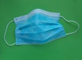 Protective medical sterile blue mask on the green background