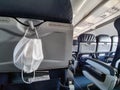Protective medical white safety mask hanging in airplane for Covid-19, Travel and coronavirus concept