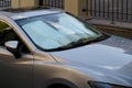 Protective reflective surface under windshield of car on hot day, heated by sun's rays inside car