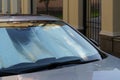 Protective reflective surface under windshield of car on hot day, heated by sun's rays inside car