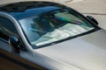 Protective reflective surface under windshield of passenger car parked on hot day. Summertime Royalty Free Stock Photo