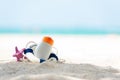 Protective sunscreen or sunblock and sunbath lotion in white plastic bottles with sandals on tropical beach, summer accessories in Royalty Free Stock Photo