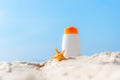 Protective sunscreen or sunblock and sunbath lotion in white plastic bottles on tropical beach, summer accessories in holiday