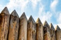 Protective wall sharp logs logs old weather-beaten impenetrable wall imprisoned element on sky background Royalty Free Stock Photo