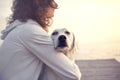 Protective woman embracing his dog while looking the view