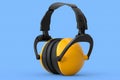 Protective yellow earphones muffs isolated on a blue background