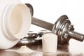 Protein powder in scoope with dumbbells in background - whey Royalty Free Stock Photo