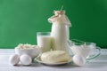 Protein products, a bottle and a glass of milk, sour cream, cottage cheese, eggs, cheese on a white table on an green Royalty Free Stock Photo