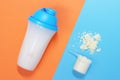 Protein shake and measuring spoon with powdered protein on blue and orange background, a copy of the space Royalty Free Stock Photo