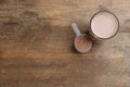 Protein shake and powder on wooden table, flat lay