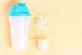 A protein shake and scoop on brown background, copy space. Royalty Free Stock Photo