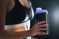 Protein shake after workout and gym training. Fit woman holding bottle of sport drink, whey or healthy smoothie. Royalty Free Stock Photo