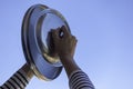 Protest against the government measures. Woman hands banging pot lids against blue sky. Banging pots and pans from the Royalty Free Stock Photo