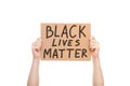 Protest hands holding a cardboard poster with the message text Black lives matter.