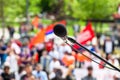Protest, public demonstration or pension reform strike, focus on microphone, blurred crowd of people in the background Royalty Free Stock Photo