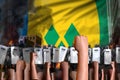 Protest in Saint Vincent and the Grenadines - police swat stand against the angry crowd on flag background, mutiny fighting