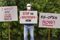 Protester with cap and medical protection mask demonstrate against stay-at-home orders due to the COVID-19 pandemic