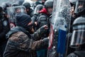 Protester confronting riot police during a tense standoff