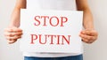 Protester hands holding cardboard Banner with the words stop putin. protesting against the Russian invasion. Royalty Free Stock Photo