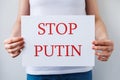 Protester hands holding cardboard Banner with the words stop putin. protesting against the Russian invasion. Royalty Free Stock Photo