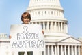 Protester holding sign I have autism in hands